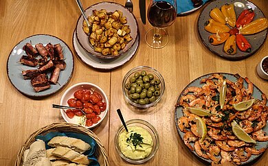Köstliches aus Spanien Auf einem großen Holztisch werden verschiedene spanische Tapas serviert.