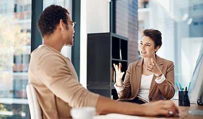 Frau und Mann im Verhandlungsgespräch am Tisch.