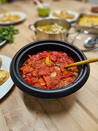 Auf einem großen Holztisch werden verschiedene spanische Tapas serviert.