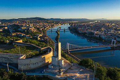 Luftaufnahme der Freiheitsstatue auf dem Gellértberg mit der Donau und mehreren Brücken in Budapest
