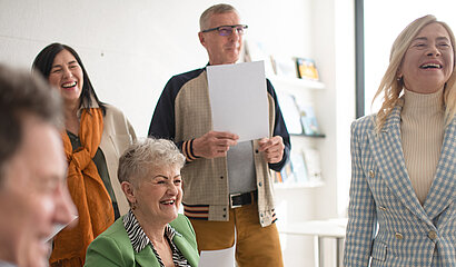eine Gruppe fröhlicher Menschen beim gemeinsamen Musizieren