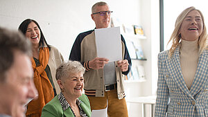 eine Gruppe fröhlicher Menschen beim gemeinsamen Musizieren