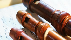 zwei Sopran- und eine Altblockflöte liegen auf einem Blatt Noten