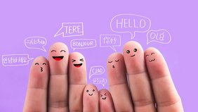 Finger, mit Gesichtern drauf. Darübe steht "Hallo" in unterschiedlichen Sprachen