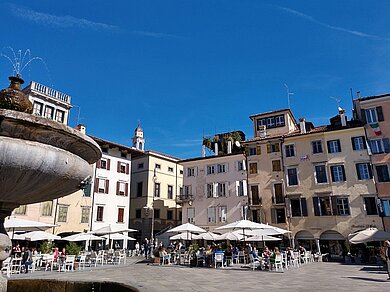 Eine Piazza in Italien mit vielen Cafès.