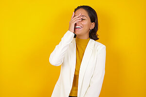 Frau im weißen Jacket vor gelbem Hintergrund