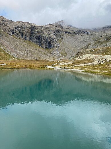 Ein türkiser See in einer Berglandschaft
