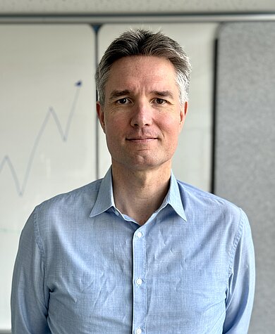 Ein Portraitbild von Matthias Struck. Er blickt mit braunen Augen freundlich in die Kamera, trägt ein hellblaues Hemd und kurz geschnittene Haare.