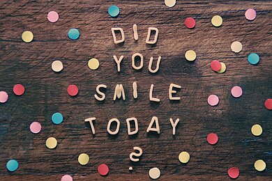 Positive Kommunikation im Business Geschriebene Wörter "Did you smile today?" Drumherum ist buntes Konfetti.