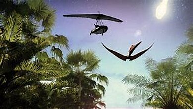 Eine Dschungellandschaft aus Zeiten der Dinosaurier. In der Luft befindet sich ein Flugsaurier, über dem ein Drachenflieger fliegt (animiert).