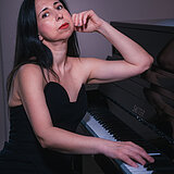 Die Künstlerin Sevi Salam sitzend am Klavier.