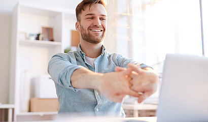 Zufriedener Mann vor dem Notebook