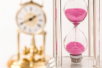 90 Minuten für optimales Zeitmanagement Sanduhr mit pinkem Sand läuft.