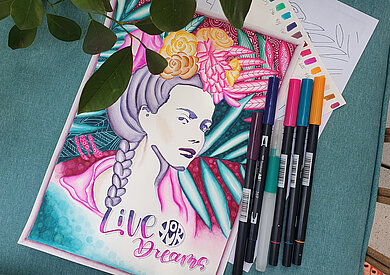 Buntes Bild einer Frau, daneben bunte Stifte.