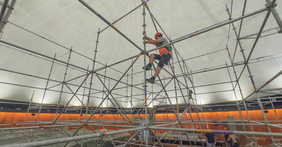 Arbeiter klettert an einem Gerüst hoch.