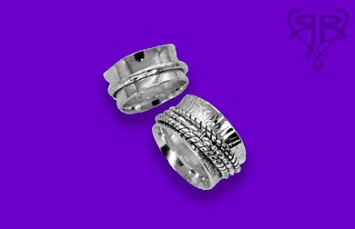 Abgebildet sind zwei breitere Ringe aus Silber, bei denen weitere schmale Ringe auf den breiteren Ring sitzen, sogen. Spielringe.