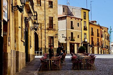 Hinter den roten Dächern einer peruanischen Stadt und der Kuppel einer Kirche erheben sich Berge.