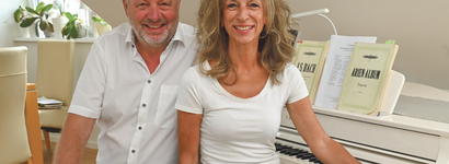 Mann und Frau vor einem Klavier. 